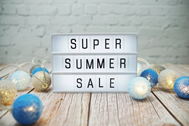 超级夏季特卖文字灯箱与LED棉球装饰在木制背景图片下载