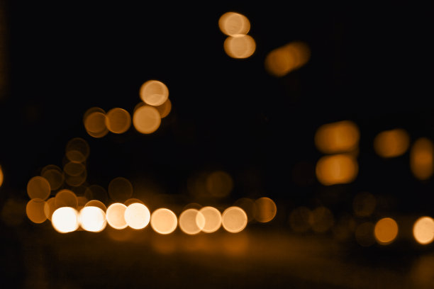 背景的夜晚街道与散景橙色模糊轻车和路灯。城市生活的离焦灯光的抽象背景。城市景观背景设计概念。复制文本空格图片下载