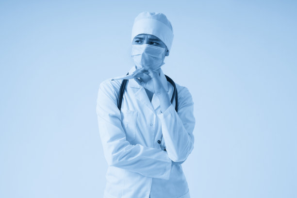 悲伤的惊讶医生戴着医用口罩拿着医用温度计在白色背景图片下载