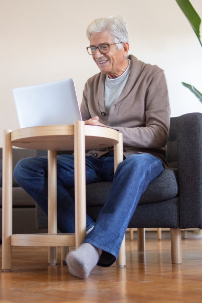 正高级男子在咖啡桌上使用笔记本电脑图片下载