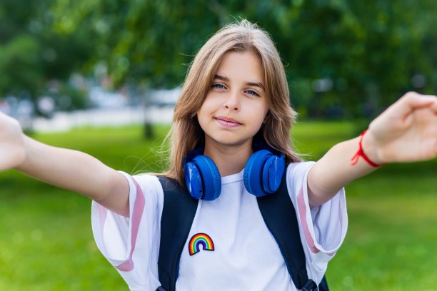 白人女孩十几岁的学生使用智能手机彩虹案件在城市公园的户外自拍图片下载