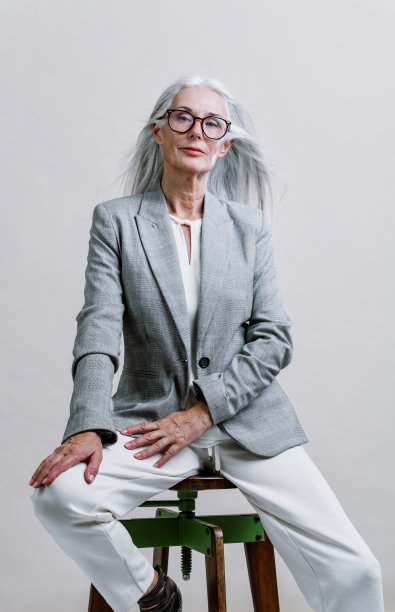 美丽的高级妇女摆姿势在一个公司的商业照片会议。图片下载