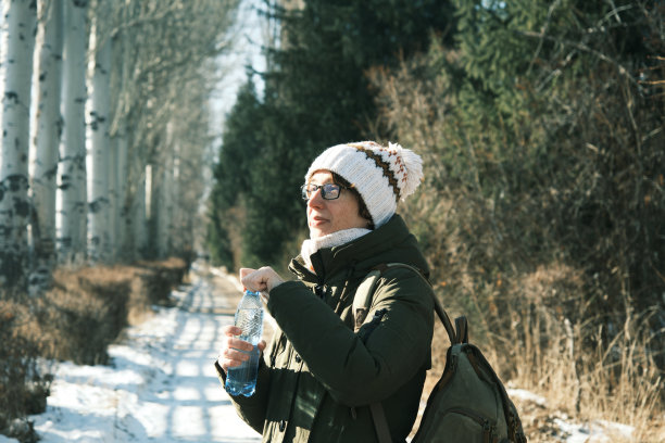 女子在冬季公园里喝水图片下载