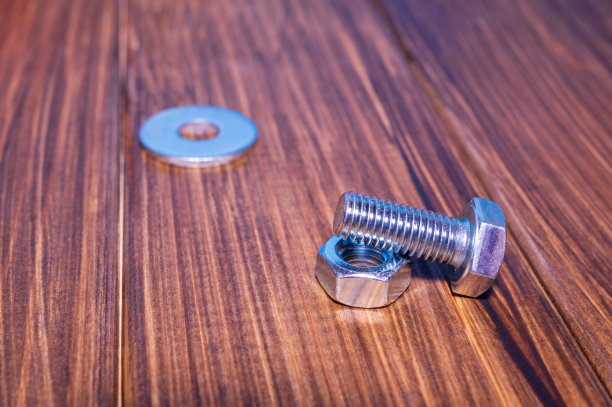 金属螺栓和螺母的复古木制背景图片下载