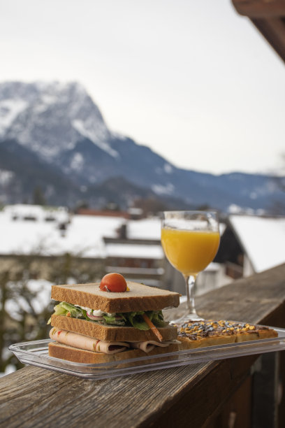 冬季客栈早餐，橙汁三明治和薄煎饼榛子奶油和欧洲阿尔卑斯山的背景图片下载