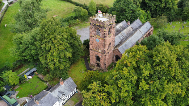 航拍英格兰温斯福德的中世纪圣查德教堂，周围环绕着绿树图片下载