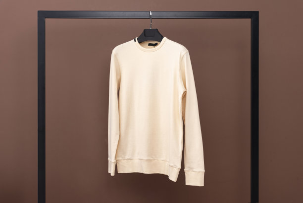 黄色运动衫挂在衣架上。图片下载