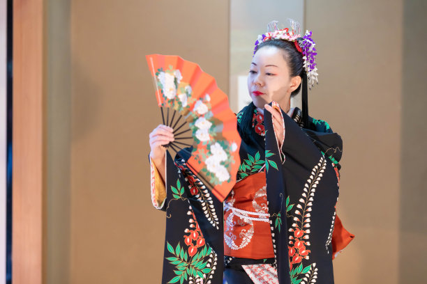 年轻的日本女子穿着和服与扇子跳着日本传统舞蹈图片下载