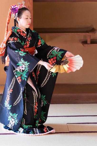 年轻的日本女子穿着和服与扇子跳着日本传统舞蹈图片下载