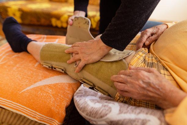 一名护士帮助一位老年妇女治疗她的腿图片下载