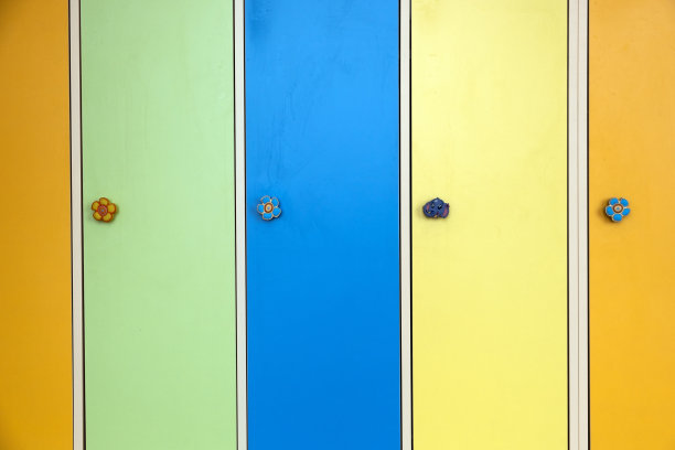 在日托学校，用有趣的动物作为门把手的彩色储物柜门的特写。图片下载