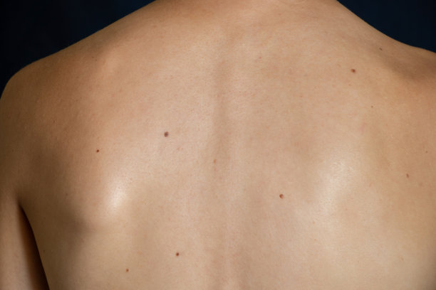 一个年轻苗条的女孩没有衣服在黑暗背景的背影图片下载