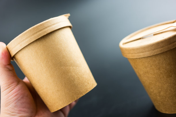 手拿圆形纸制食品容器。图片下载