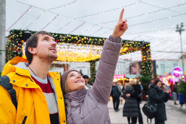 快乐的年轻人在城市街道上仰望，享受圣诞节。情人节，节日概念图片下载