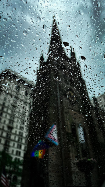从覆盖着水滴的玻璃后面拍摄的哥特式教堂或大教堂的垂直镜头图片下载