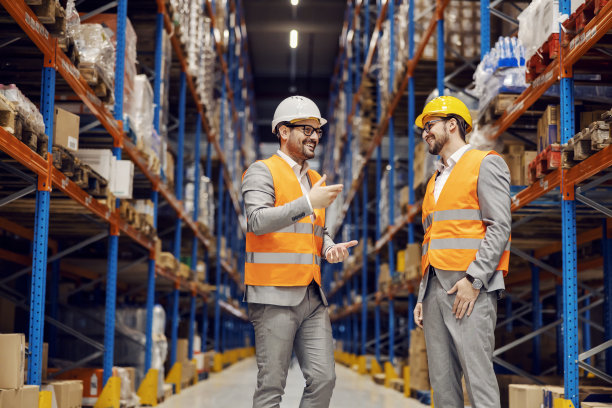 商人在仓库和他的生意伙伴聊天。图片下载