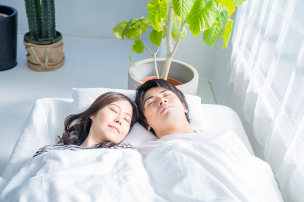 一对年轻夫妇睡在卧室的床上。图片下载