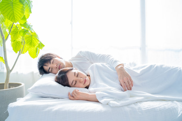 一对年轻夫妇睡在卧室的床上。图片下载