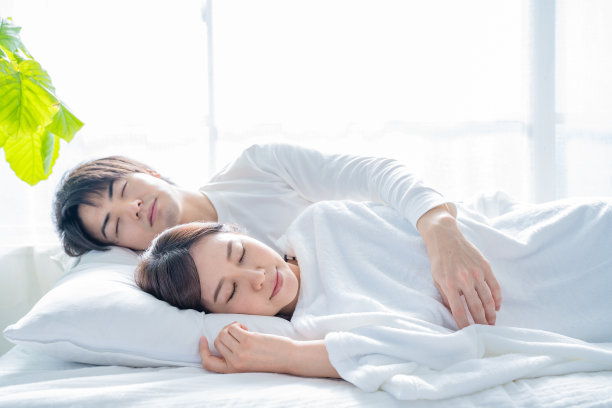 一对年轻夫妇睡在卧室的床上。图片下载