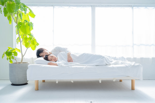 一对年轻夫妇睡在卧室的床上。图片下载