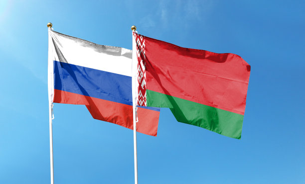 俄罗斯国旗和白俄罗斯国旗在多云的天空。在天空中舞动图片下载