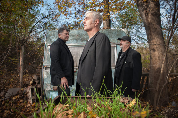 三个时尚的艺术家在户外穿着黑色优雅的西装图片下载