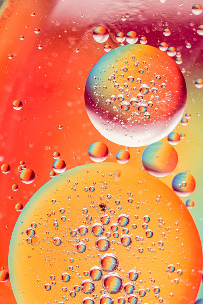 油滴在水面上。明亮的抽象背景，不同大小的彩色球。微距照片，选择性对焦。图片下载