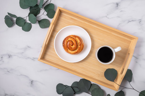 瑞典哲学的平衡生活理念Lagom。Fuss-free。舒适的早晨，一杯咖啡，自制的小面包，大理石背景的木托盘上放着桉树树枝。俯视图，复制空间。图片下载