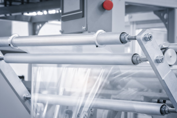 带照明效果的全自动聚乙烯塑料袋生产机。浅蓝色场景中塑料袋生产机滚筒的特写。产品包装概念图片下载