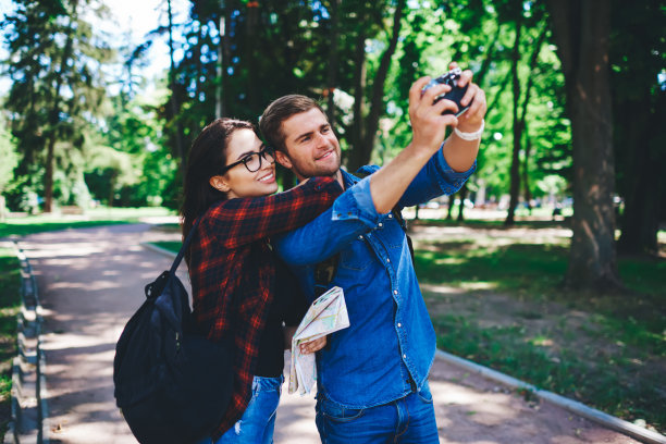 开朗的白人男女潮人在相机前摆出常见的自拍照，一起在城市旅行，开朗的情侣在爱中拍照，享受假期和旅行游览城市图片下载