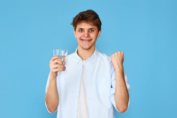 年轻英俊的男人拿着一杯水图片下载