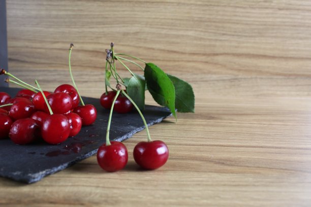 樱桃放在桌子上的黑色托盘上。成熟的浆果特写。健康饮食健康日樱桃维生素C图片下载