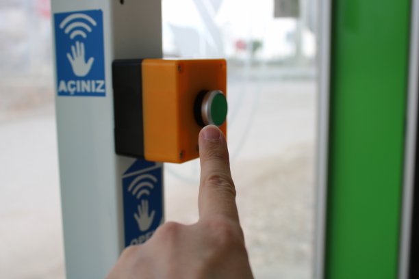 一只男性的手按着一个红色的按钮。火灾和紧急情况通知。按钮打开车站门。图片下载