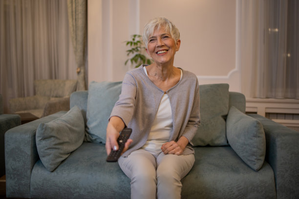 女人在家里享受她最喜欢的电视节目图片下载