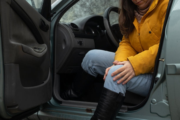 当这位女士下车时，她感到膝盖疼痛。图片下载