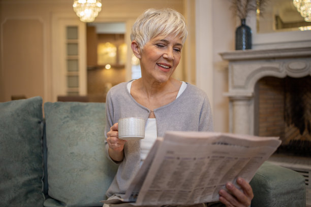 老女人坐在家里看报纸图片下载