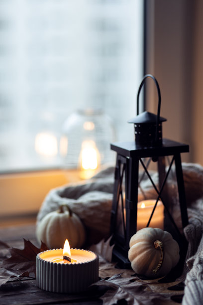 芬芳的蜡烛，南瓜，羊毛衫，树叶，肉桂组成舒适的秋天。在一个灰色的秋天的早晨，芳香疗法，舒适和放松的家庭气氛。木质背景特写。图片下载