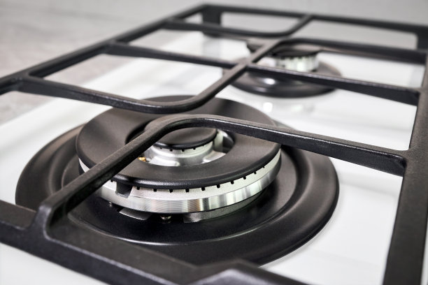 滚刀炊具烤箱炉由白色玻璃烤架不锈钢燃烧器和烤架选择性聚焦在焦外烤箱与燃烧器在台面制成的陶瓷石器背景。图片下载