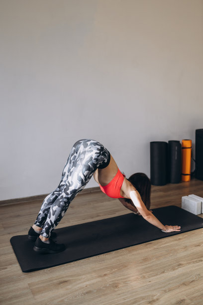 年轻有魅力的女子练习瑜伽，做向下的狗运动，adho mukha svanasana姿势。健身运动理念。图片下载