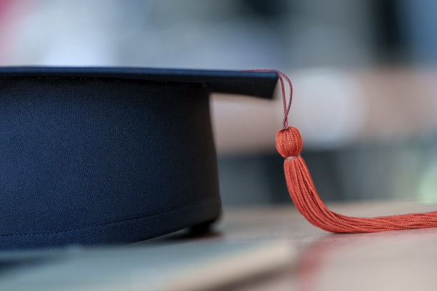 黑色毕业帽放置在木材背景图片下载