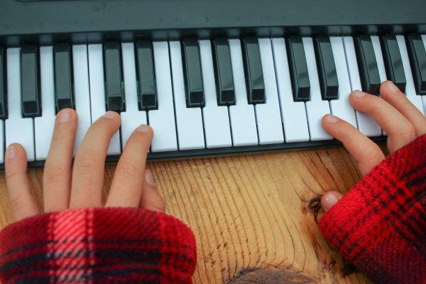 男孩手玩玩具钢琴键盘图片下载