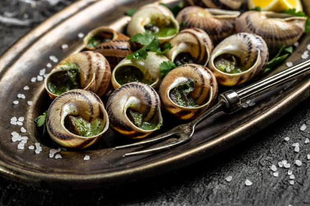 烤蜗牛配酱，勃艮第蜗牛。烤蜗牛配黄油和香料。美味的食物。配方的背景。近距离图片下载