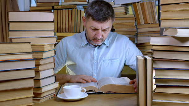 一个大胡子男人在图书馆看书图片下载