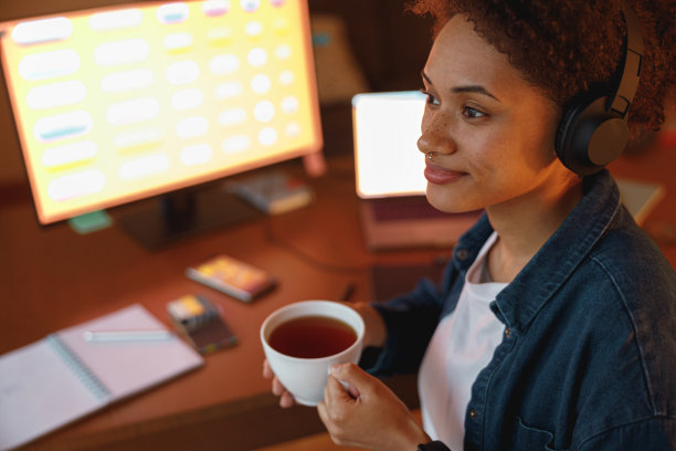 美国黑人女性平面设计师喝茶在休息期间在家里办公室。自由的概念图片下载