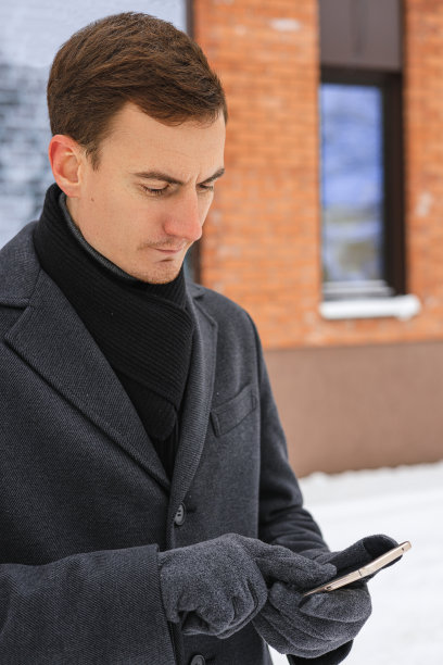 男性企业家在城市冬天使用智能手机图片下载