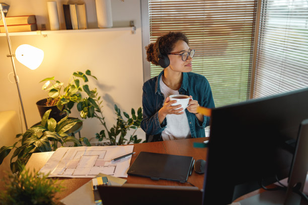 非裔美国女性室内设计师喝茶在休息期间在家里的办公室。自由的概念图片下载