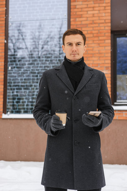 坚定的男性企业家，咖啡和电话在冬天的城市图片下载