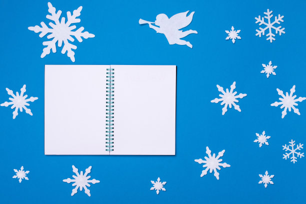 白色空白记事本，蓝色背景，圣诞雪花，白色天使吹小号图片下载