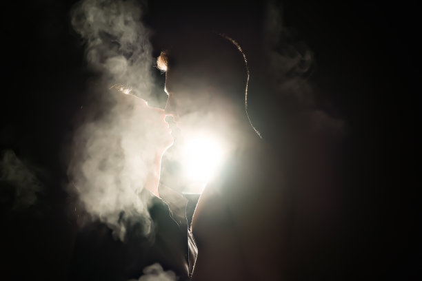一个男人和一个女孩的剪影。男人和女人在黑暗中。烟。蒸汽。一个男人和一个女孩在黑暗的房间里拥抱。爱的概念。图片下载