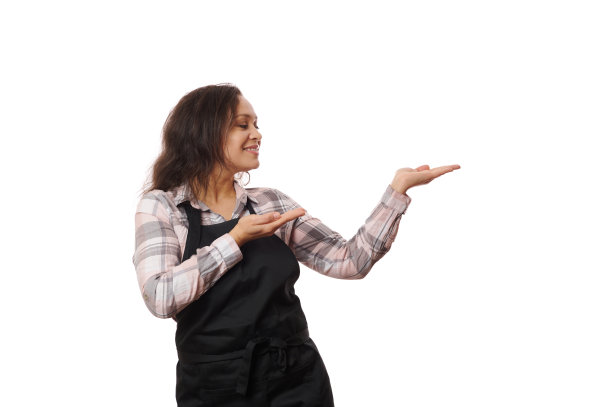 开朗的拉丁美洲女招待，酒吧女服务员，女调酒师穿着黑色的厨师围裙，指着白色的复制空间图片下载